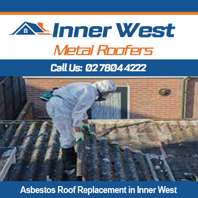 Worker in protective gear removing old asbestos roof in Inner West